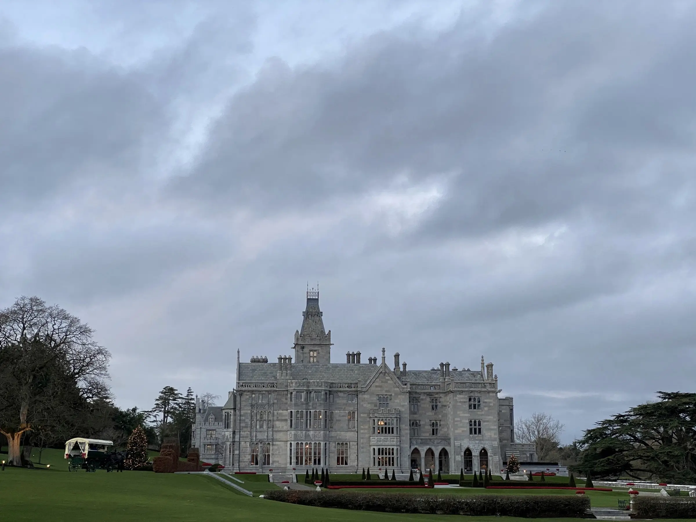 Adare Manor seen across the putting green of its golf course on a grey morning