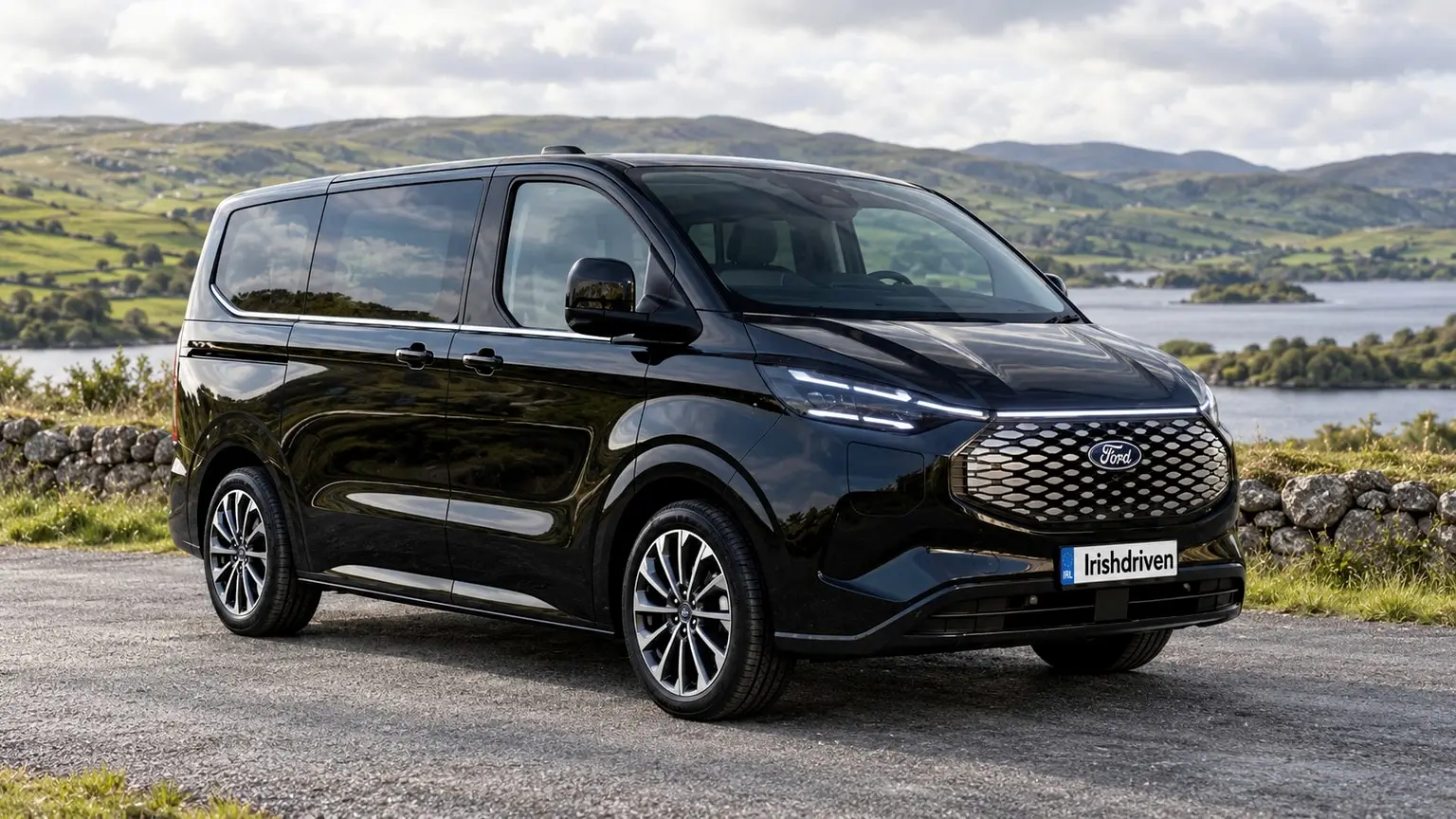 A black seven-seat Business MPV beside a lake in the Irish countryside