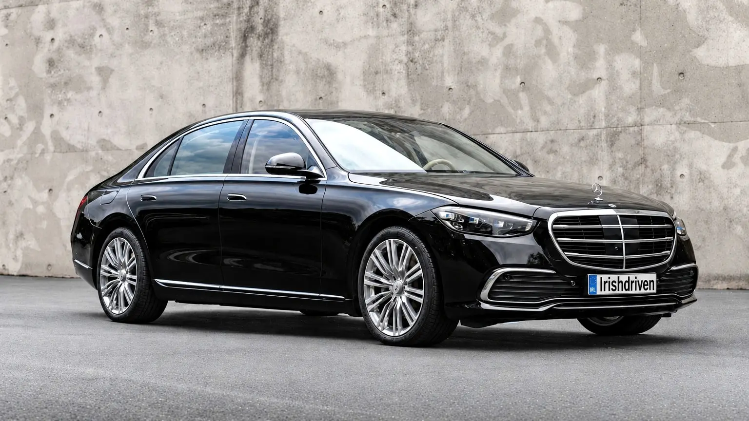 A black Mercedes-Benz S-Class saloon in front of a concrete wall