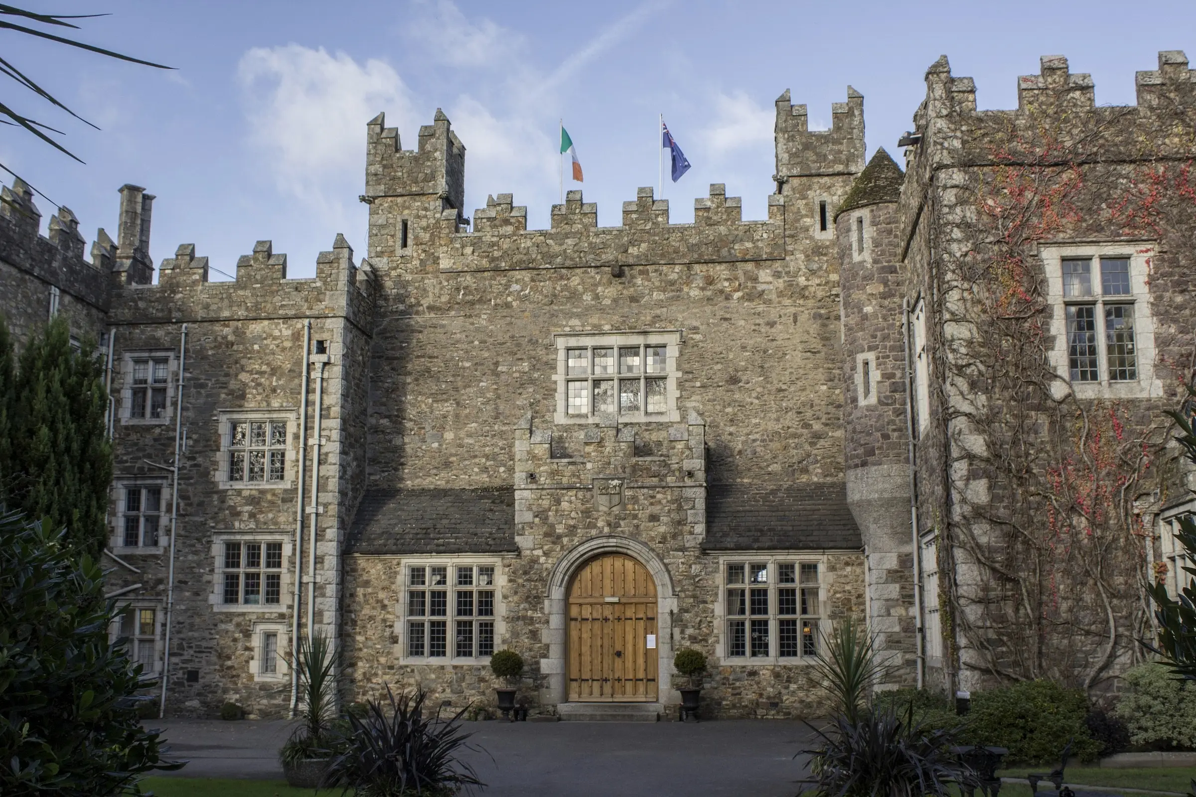 The battlemented stone front of Waterford Castle under a blue sky
