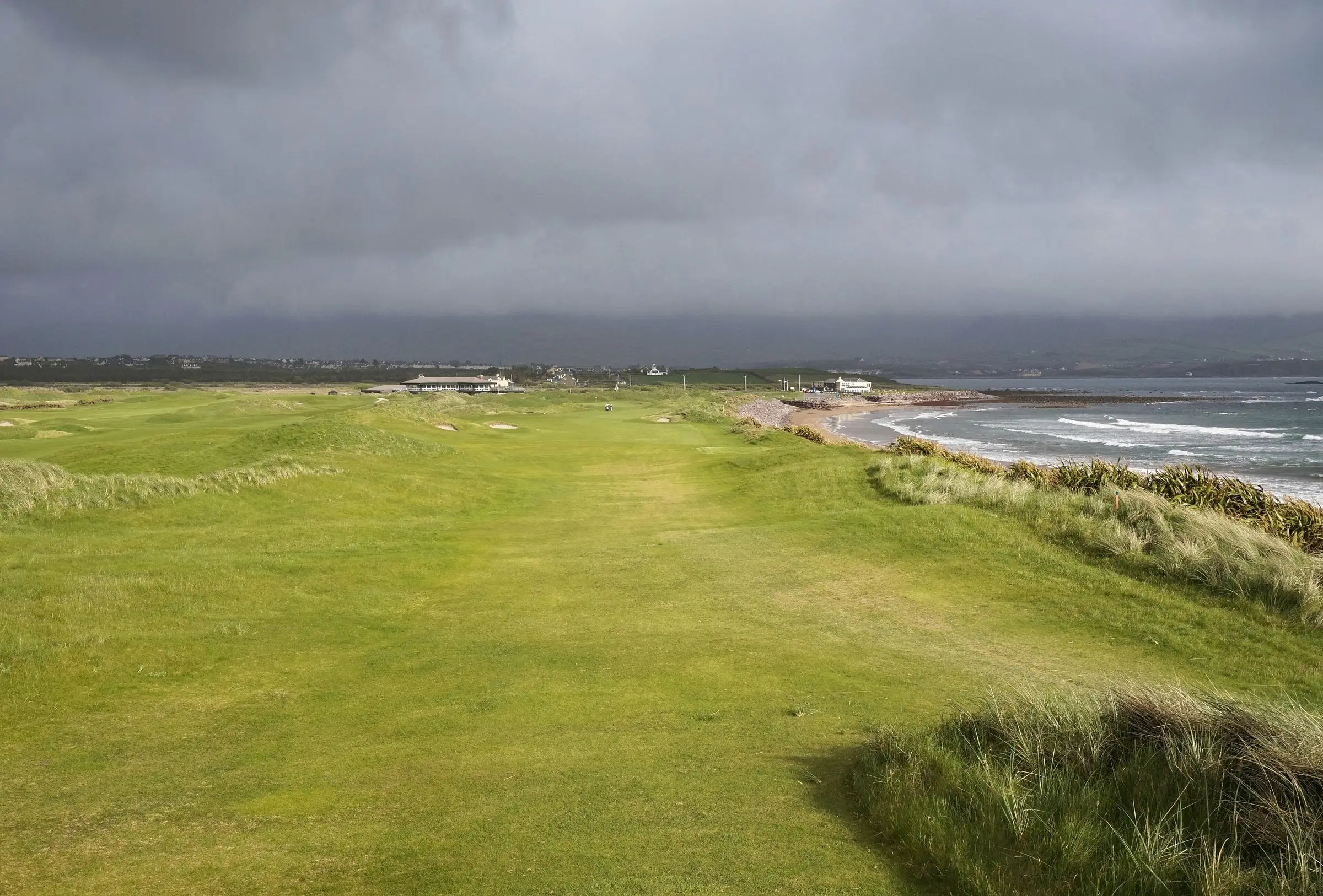 The 18th hole at Waterville Golf Links beside Ballinskelligs Bay, under a stormy Kerry sky